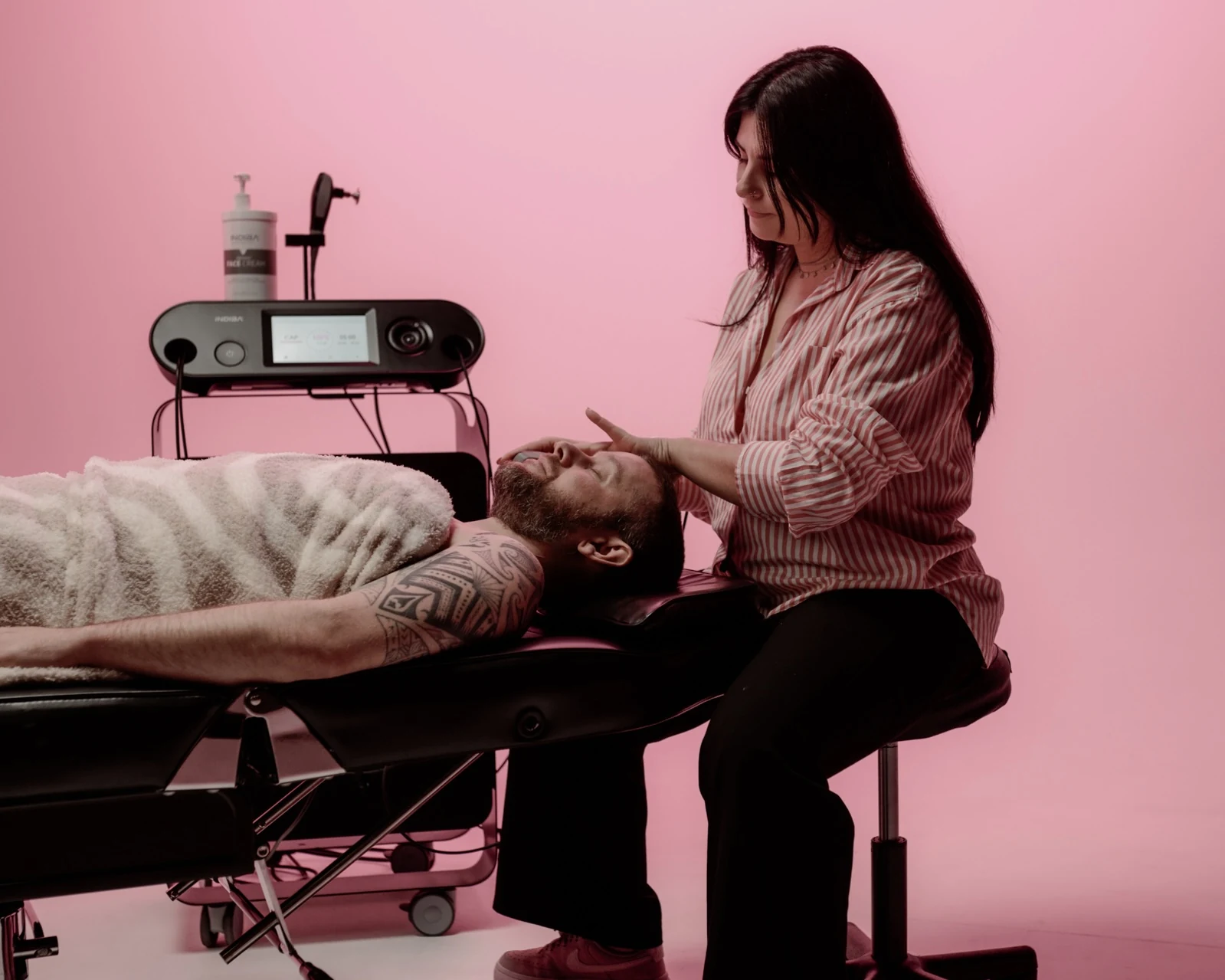 Séance de radiofréquence INDIBA® du visage chez AlyCare : la praticienne masse le visage d'une cliente allongée, à côté de l'appareil INDIBA®.